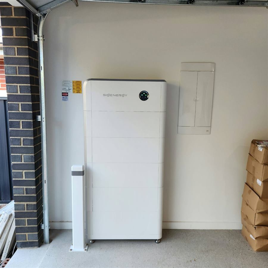 Home battery installed on a garage wall beside the switchboard